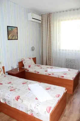 a bedroom with two beds and a window at Hotel Trakia in Pazardzhik