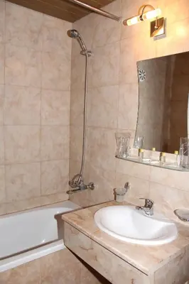 a bathroom with a sink and a tub and a mirror at Hotel Trakia in Pazardzhik