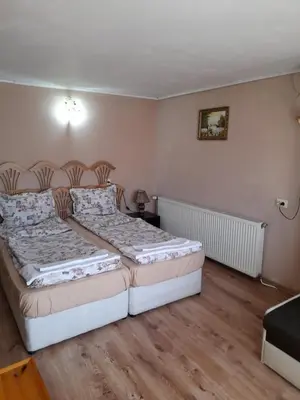 two beds in a room with wooden floors at Yana Guest House in Dobrinishte