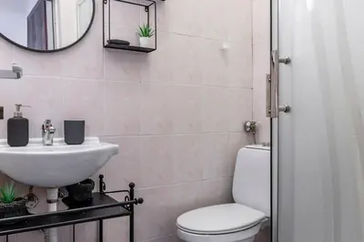 a bathroom with a toilet and a sink and a mirror at Apartment 11 in Sofia