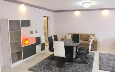 a dining room with a table and chairs and a couch at Sundance Apartments in Sandanski