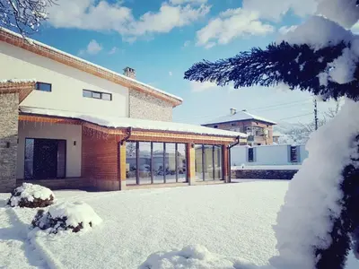 a house with snow on the ground in front of it at Vila Antik in Garmen