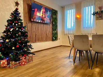 a christmas tree in a living room with presents at Вила Флора Паталеница in Patalenitsa