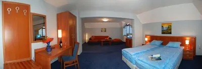 a hotel room with a bed and a desk and a bedroom at Hotel Kibella in Sofia