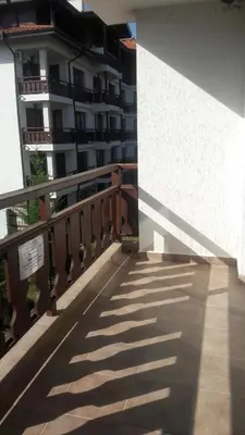 a balcony of a building with a shadow on the ground at Oksana's Apartment at Infinity in Bansko
