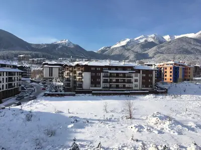 a city in the snow with mountains in the background at Oksana's Apartment at Infinity in Bansko