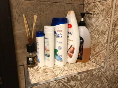 a shelf with four bottles of hair products on it at Golden Dome view Apartment in Sofia