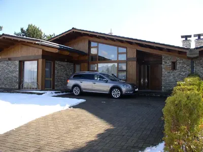 a car parked in a parking lot in front of a house at LVV Pirin Golf Villa in Bansko