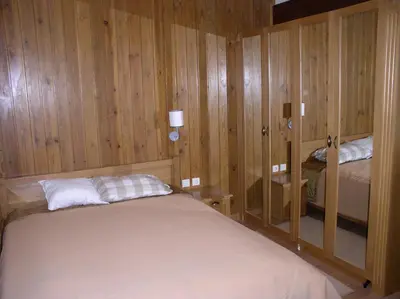 a small bedroom with a bed and wooden walls at LVV Pirin Golf Villa in Bansko