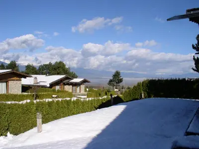 a snow covered driveway with a house in the background at LVV Pirin Golf Villa in Bansko