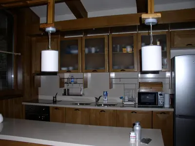 a kitchen with wooden cabinets and a stainless steel refrigerator at LVV Pirin Golf Villa in Bansko