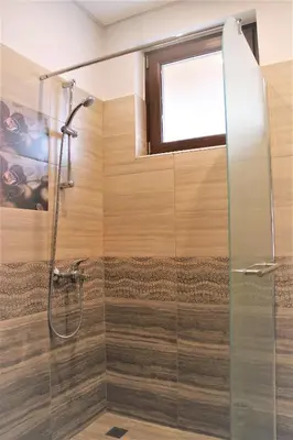 a bathroom with a shower with a glass door at Rupchini Houses in Bansko
