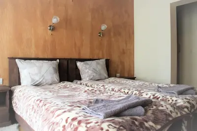 a bed with a blanket and two towels on it at Rupchini Houses in Bansko