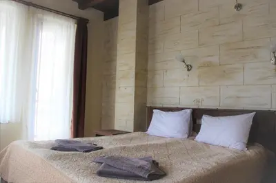 a bedroom with a bed with two towels on it at Rupchini Houses in Bansko