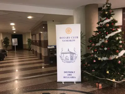 a christmas tree in a lobby with a sign at Studio in Hotel Flora Borovets in Borovets