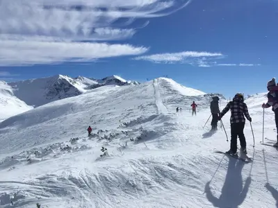 a group of people skiing down a snow covered mountain at Studio in Hotel Flora Borovets in Borovets