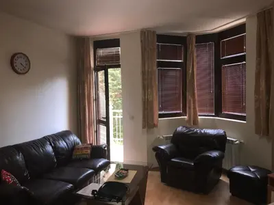 a living room with a black leather couch and chairs at Studio in Hotel Flora Borovets in Borovets