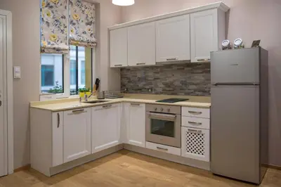 a kitchen with white cabinets and a refrigerator at The North Tower Apartment in Sofia