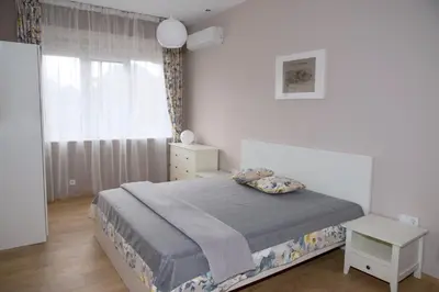 a white bedroom with a bed and a window at The North Tower Apartment in Sofia