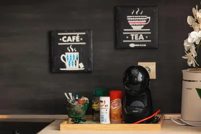 a table with a coffee maker and cups on it at City Center Apartments with Parking in Plovdiv