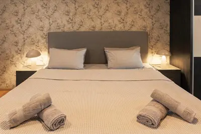 a bedroom with a large bed with two towels on it at City Center Apartments with Parking in Plovdiv