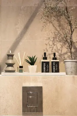 a shelf with three bottles of soap and plants at City Center Apartments with Parking in Plovdiv