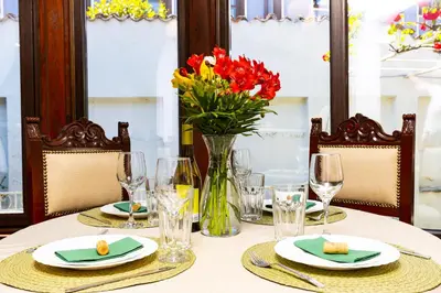 a table with a vase of flowers on top of it at The House With The Piano in Plovdiv