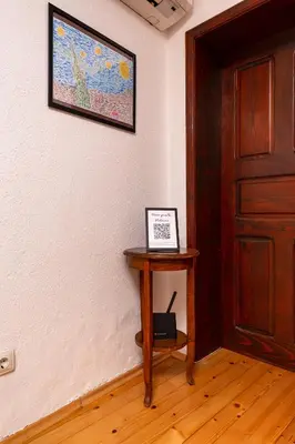 a room with a table with a picture on the wall at The House With The Piano in Plovdiv
