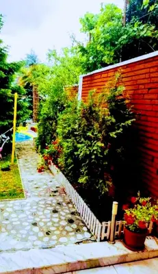 a garden with a brick wall and some plants at Guest House Sofia in Sandanski