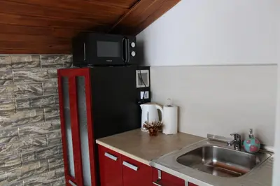 a kitchen with a red refrigerator with a tv on top at Guest House Lila in Bansko
