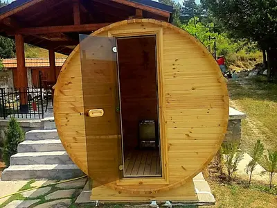 a wooden outhouse with a revolving door in a yard at Villa Rupcovoto in Smolyan