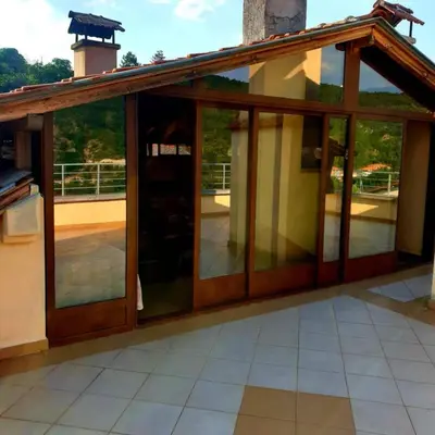 an extension to a house with glass doors at Къща за гости 