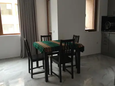 a dining room table with chairs and a green table cloth at Apartment Spa Holidays in Sandanski