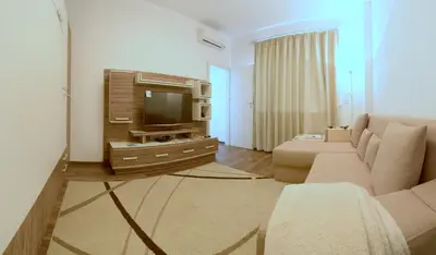 a living room with a couch and a tv at Sunshine Sofia in Sofia