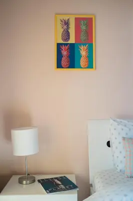 a bedroom with a bed with a lamp and a picture of pineapple at Veli Hills Apartments in Velingrad
