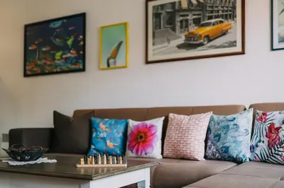 a living room with a couch with pillows and a table at Veli Hills Apartments in Velingrad