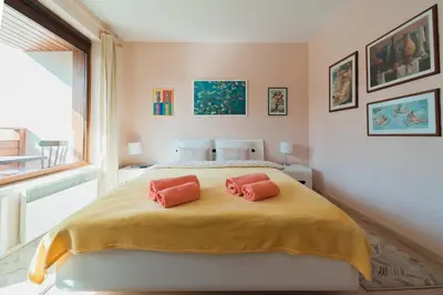 a bedroom with a bed with two pink pillows on it at Veli Hills Apartments in Velingrad
