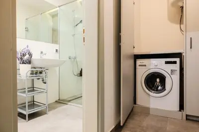 a bathroom with a washing machine and a sink at Casa Dolce Far Niente, 2BATH&2BED, PARKING, Vitosha blvd in Sofia