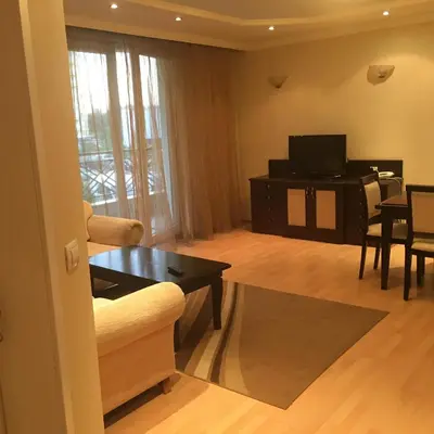 a living room with a couch and a tv and a table at Alex Apartment Sofia in Sofia