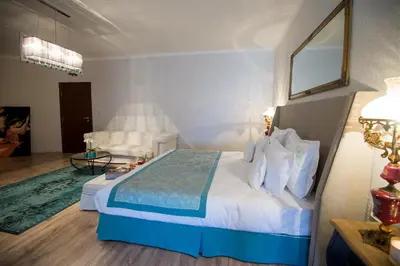 a bedroom with a bed and a living room at Hotel Tempo Boutique in Pazardzhik