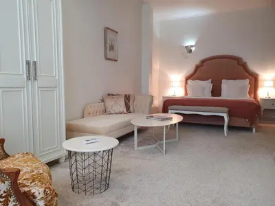 a living room with a bed and a couch and tables at Hotel Tempo Boutique in Pazardzhik