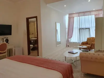 a hotel room with a bed and a living room at Hotel Tempo Boutique in Pazardzhik