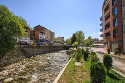 a river in the middle of a city with buildings at Apartments KiM Sandanski in Sandanski