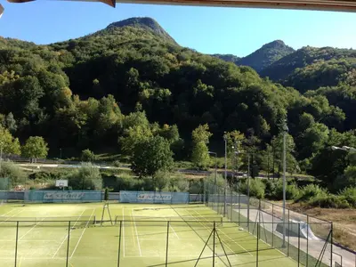 a tennis court with mountains in the background at Guest House Lori in Teteven