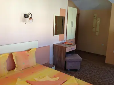 a bedroom with a bed and a vanity and a mirror at Guest House Lori in Teteven