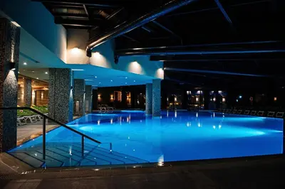 a large swimming pool in a building at night at Hot Springs Medical and SPA in Banya