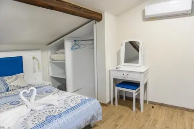 a bedroom with a bed and a dresser and a mirror at Къща за гости Мурите in Sapareva Banya