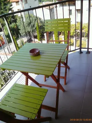 a green table and two chairs on a balcony at Vila Bachkovo in Bachkovo