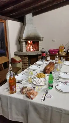a table with plates of food and a fireplace at Kavdanski Guesthouse in Sapareva Banya