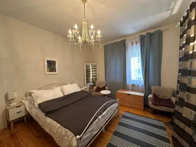 a bedroom with a bed and a chandelier at CityCentre Gem with Free Parking in Plovdiv